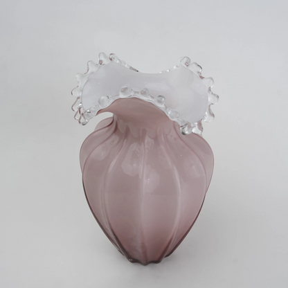 Blush pink translucent glass vase with curved body and sculptural ruffled rim.