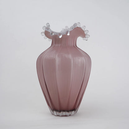 Blush pink translucent glass vase with curved body and sculptural ruffled rim.