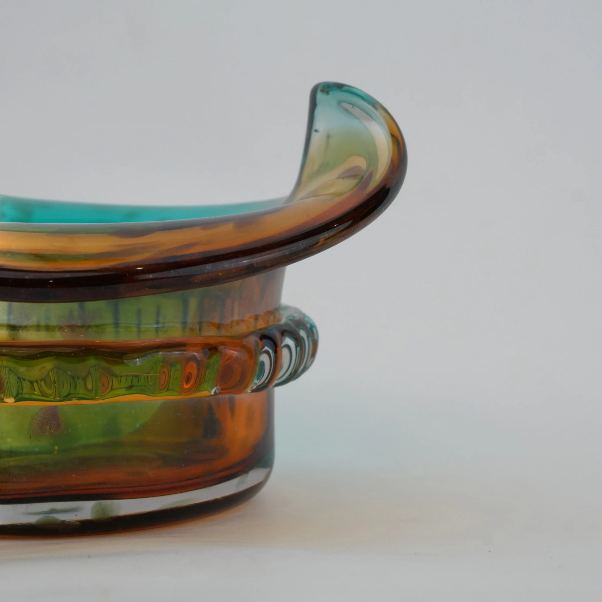 Dual-tone aqua and amber glass vase with sculptural wave-shaped rim and rounded base.