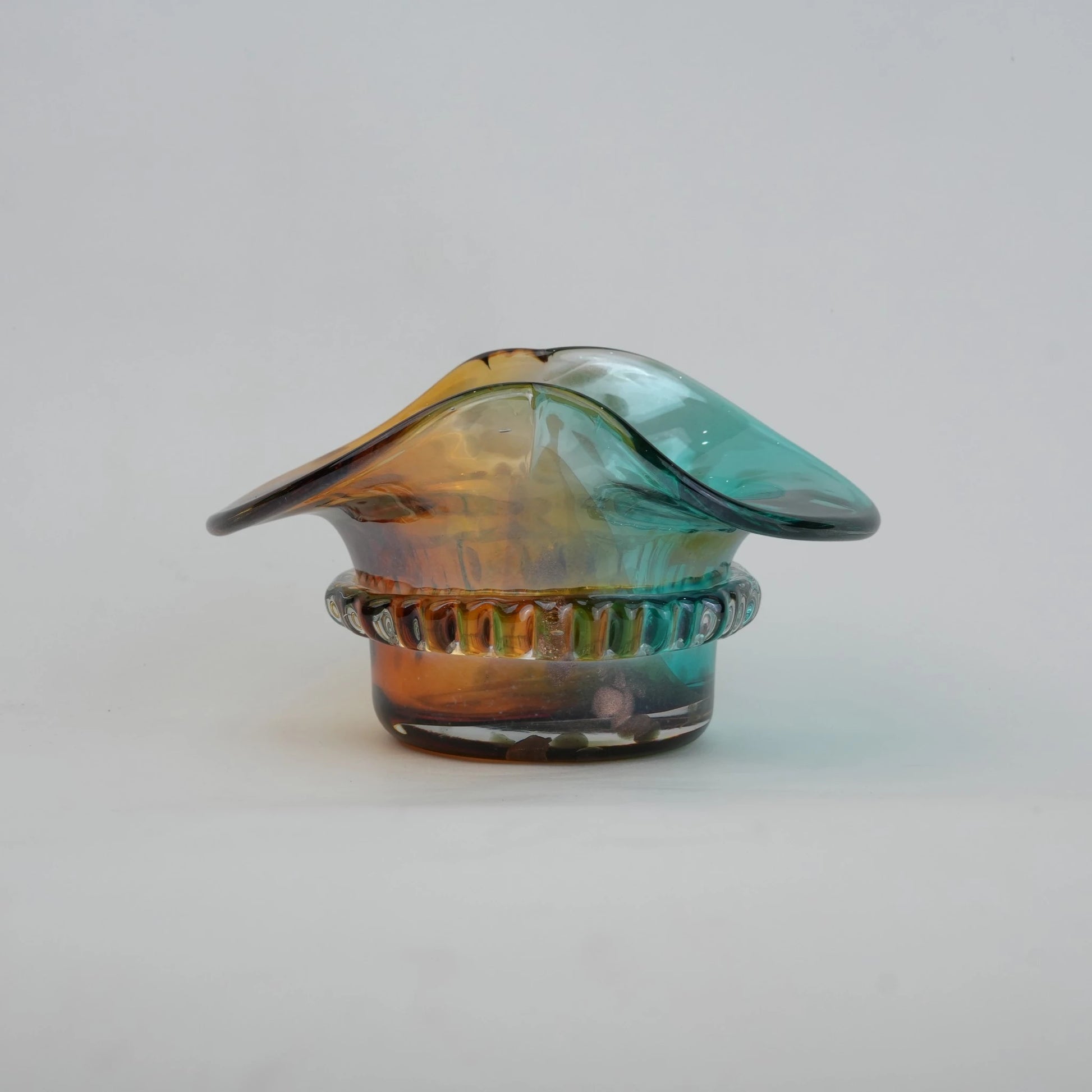Dual-tone aqua and amber glass vase with sculptural wave-shaped rim and rounded base.