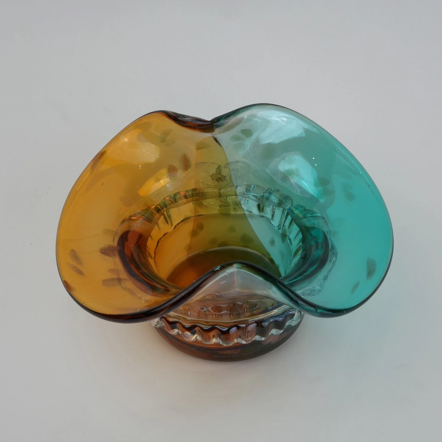 Dual-tone aqua and amber glass vase with sculptural wave-shaped rim and rounded base.