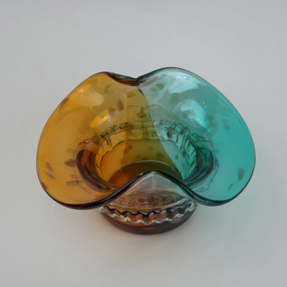 Dual-tone aqua and amber glass vase with sculptural wave-shaped rim and rounded base.
