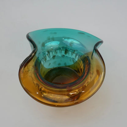 Dual-tone aqua and amber glass vase with sculptural wave-shaped rim and rounded base.