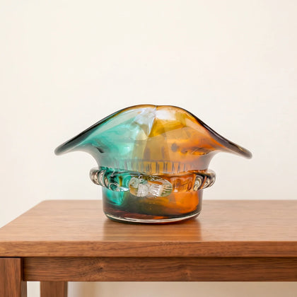 Dual-tone aqua and amber glass vase with sculptural wave-shaped rim and rounded base.