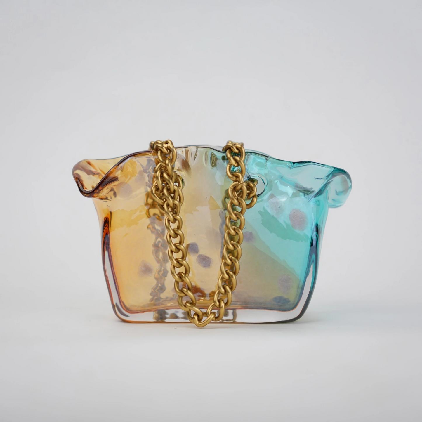 Dual-tone teal and amber glass vase with bubble texture, sculptural form, and metallic chain handle.