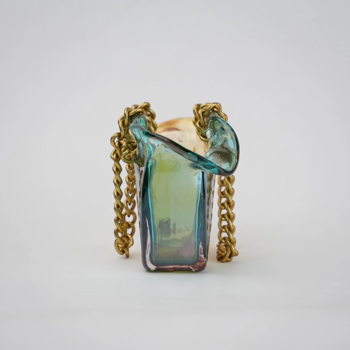 Dual-tone teal and amber glass vase with bubble texture, sculptural form, and metallic chain handle.