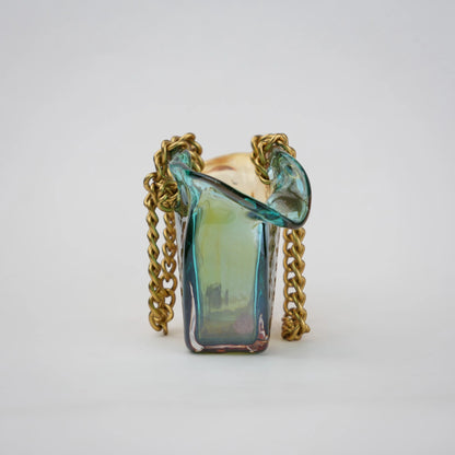 Dual-tone teal and amber glass vase with bubble texture, sculptural form, and metallic chain handle.