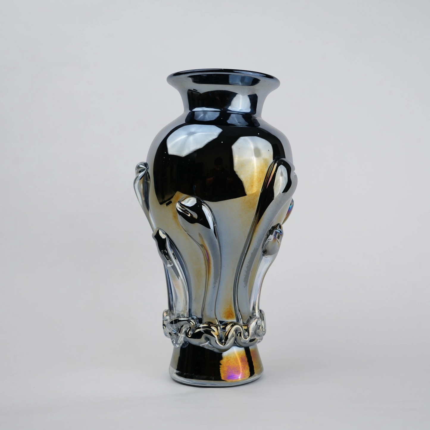 Chrome smoke reflective glass vase with curved body and metallic finish.