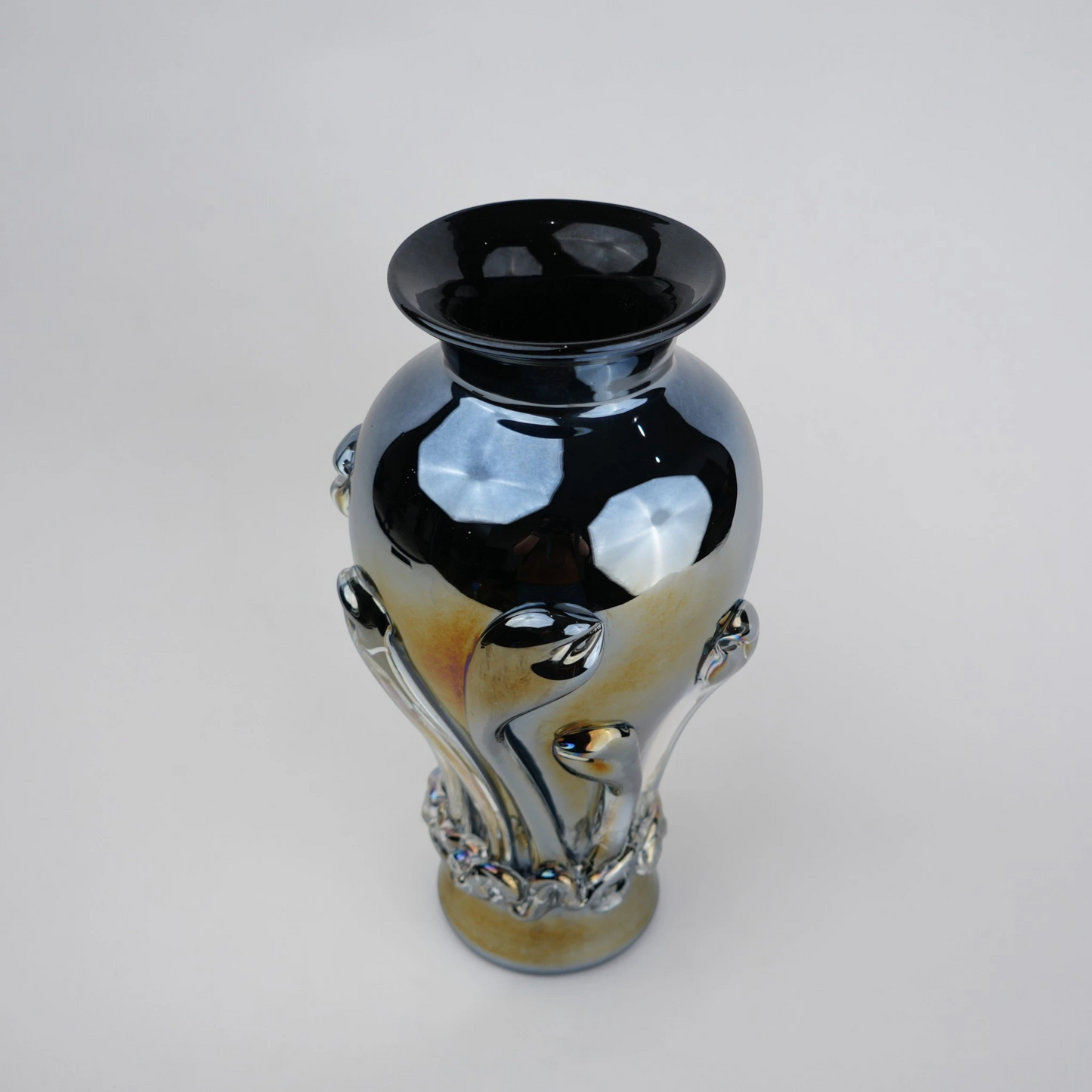 Chrome smoke reflective glass vase with curved body and metallic finish.