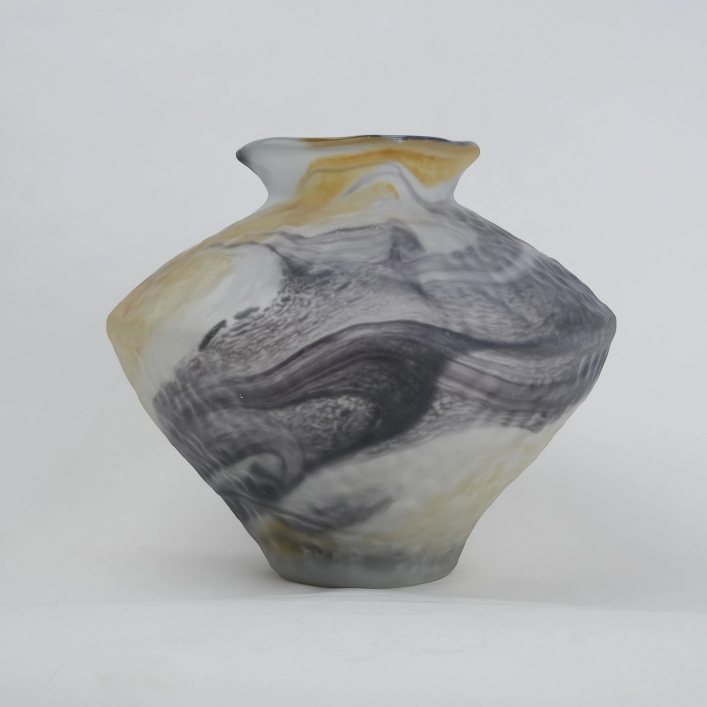 White marble art glass vase with organic pattern and wide asymmetrical form.