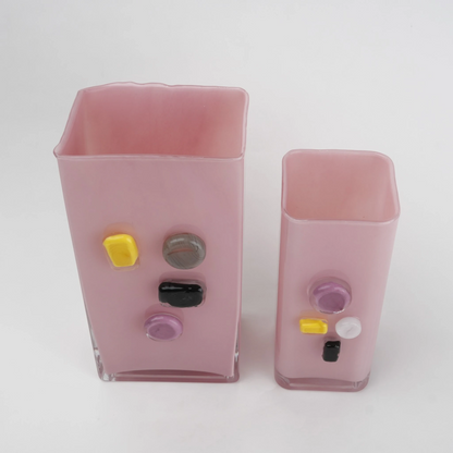 Pink art glass vase with embedded multicolor accents and wide rectangular form.