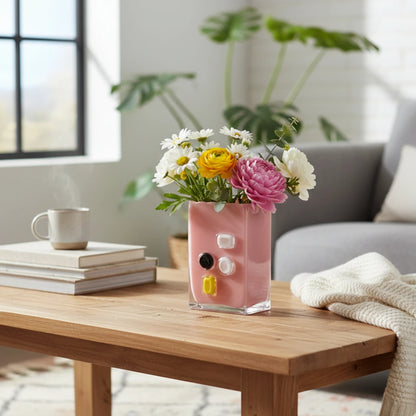 Pink art glass vase with embedded multicolor accents and wide rectangular form.