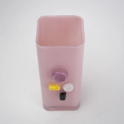 Pink art glass vase with embedded multicolor accents and wide rectangular form.