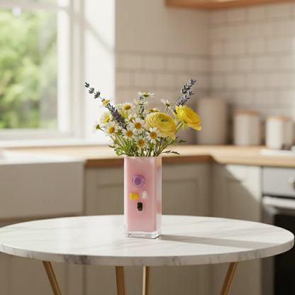 Pink art glass vase with embedded multicolor accents and wide rectangular form.