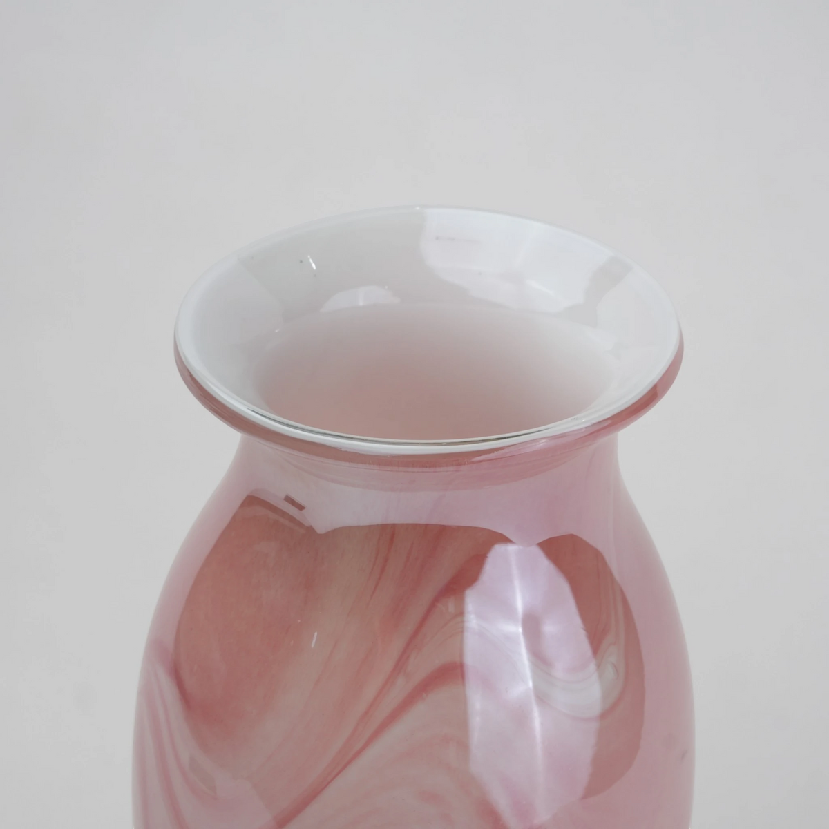 Pink marble glass vase with elongated silhouette and smooth finish.