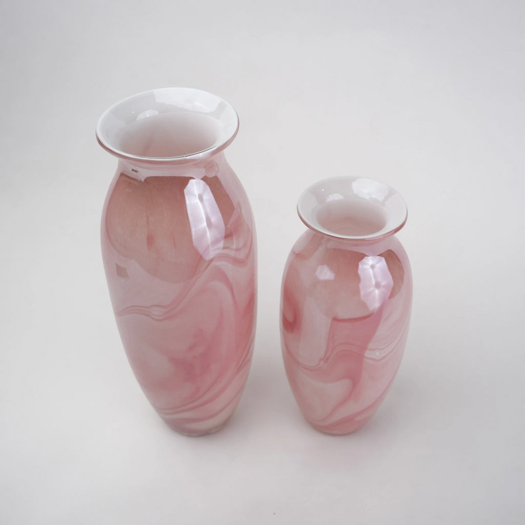 Pink marble glass vase with elongated silhouette and smooth finish.