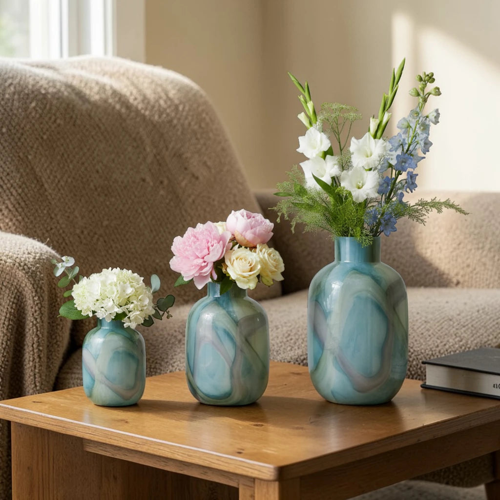 Blue marble effect glass vase with a smooth glossy finish, featuring a rounded body and short cylindrical neck, designed as a modern decorative piece for home decor styling.