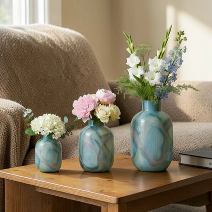 Blue marble effect glass vase with a smooth glossy finish, featuring a rounded body and short cylindrical neck, designed as a modern decorative piece for home decor styling.