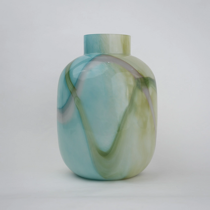 Blue marble effect glass vase with a smooth glossy finish, featuring a rounded body and short cylindrical neck, designed as a modern decorative piece for home decor styling.