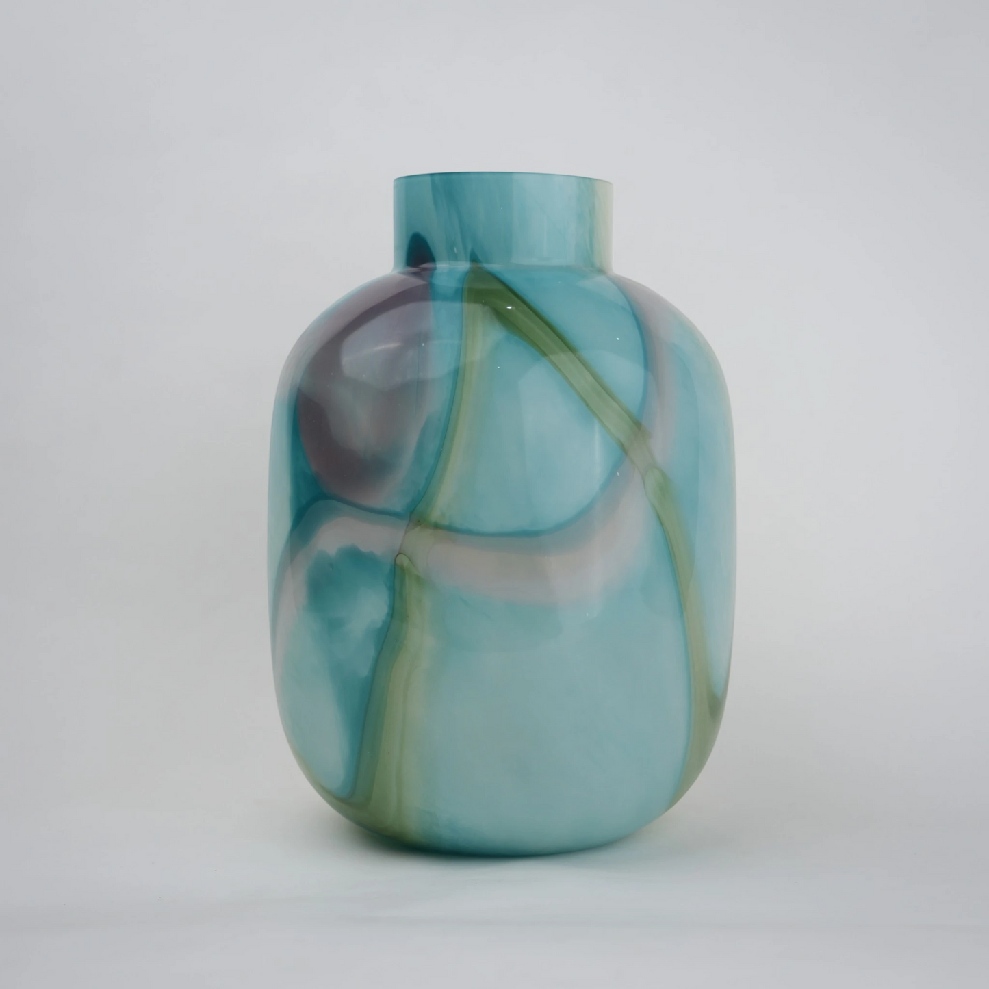 Blue marble effect glass vase with a smooth glossy finish, featuring a rounded body and short cylindrical neck, designed as a modern decorative piece for home decor styling.