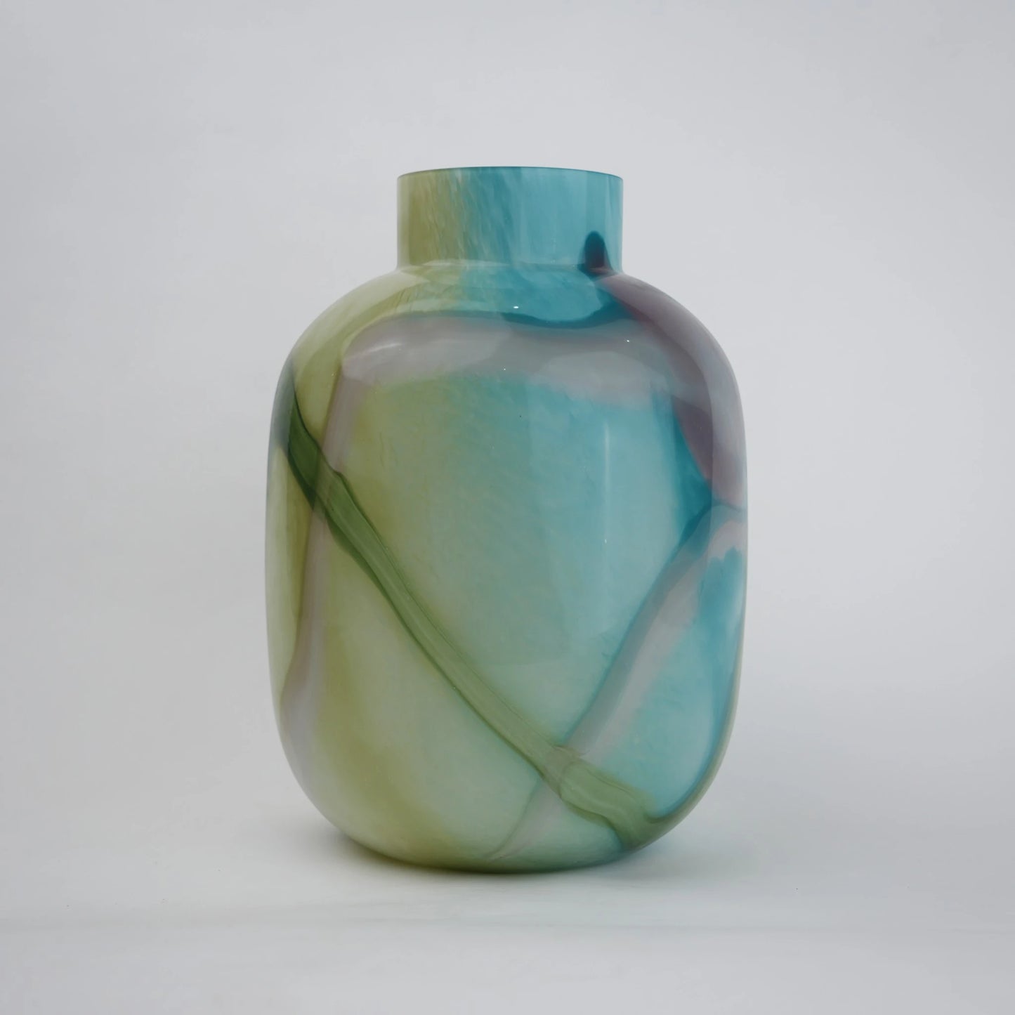 Blue marble effect glass vase with a smooth glossy finish, featuring a rounded body and short cylindrical neck, designed as a modern decorative piece for home decor styling.