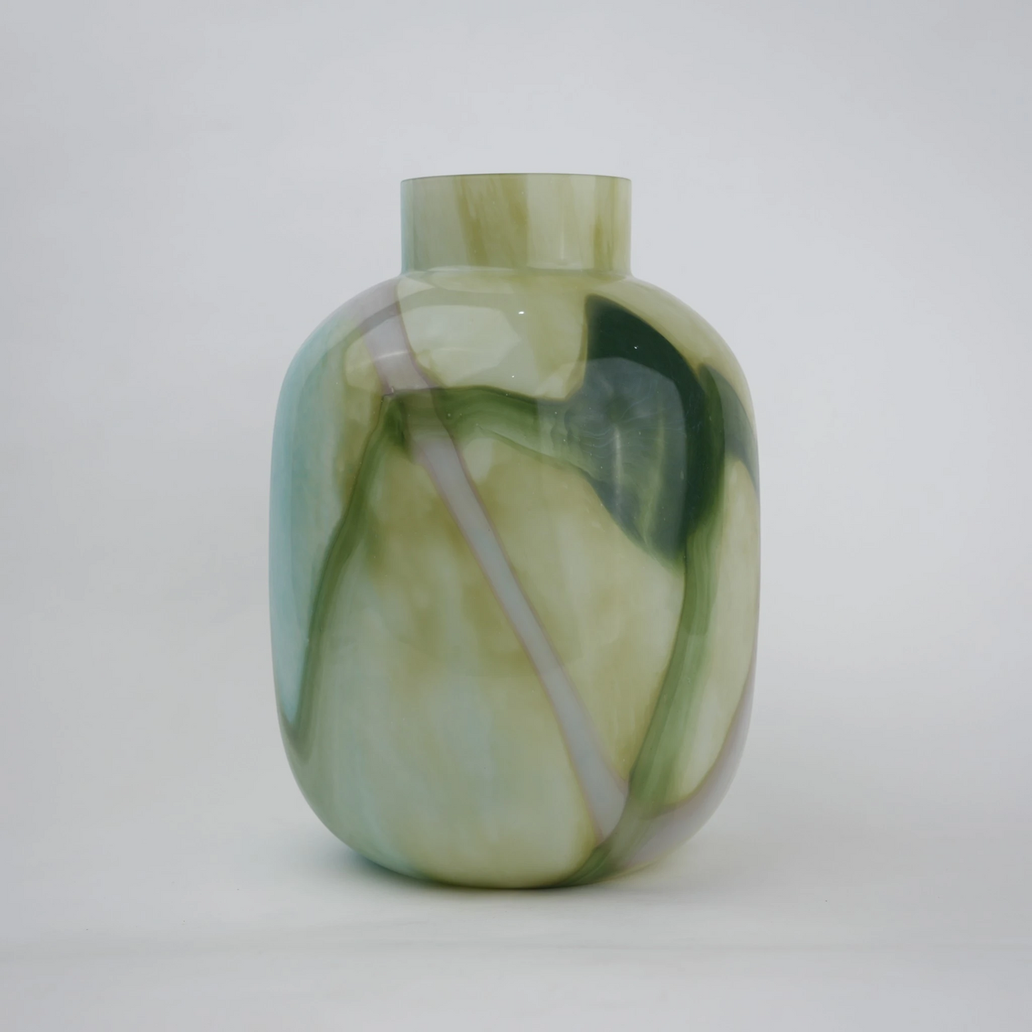 Blue marble effect glass vase with a smooth glossy finish, featuring a rounded body and short cylindrical neck, designed as a modern decorative piece for home decor styling.