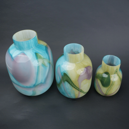 Blue marble effect glass vase with a smooth glossy finish, featuring a rounded body and short cylindrical neck, designed as a modern decorative piece for home decor styling.