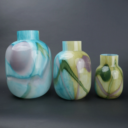 Blue marble effect glass vase with a smooth glossy finish, featuring a rounded body and short cylindrical neck, designed as a modern decorative piece for home decor styling.