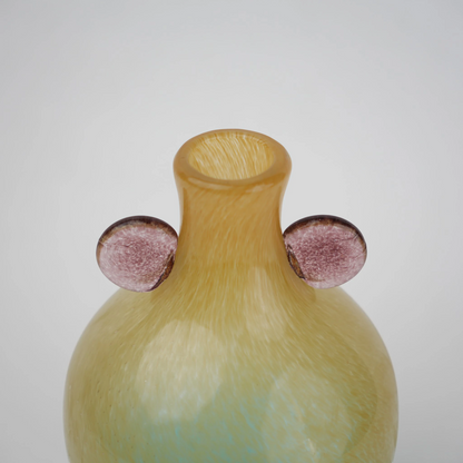 Ombre glass vase with a yellow to teal gradient finish, featuring a rounded body, narrow neck, and decorative side accents, designed as a modern artistic piece for home decor styling.