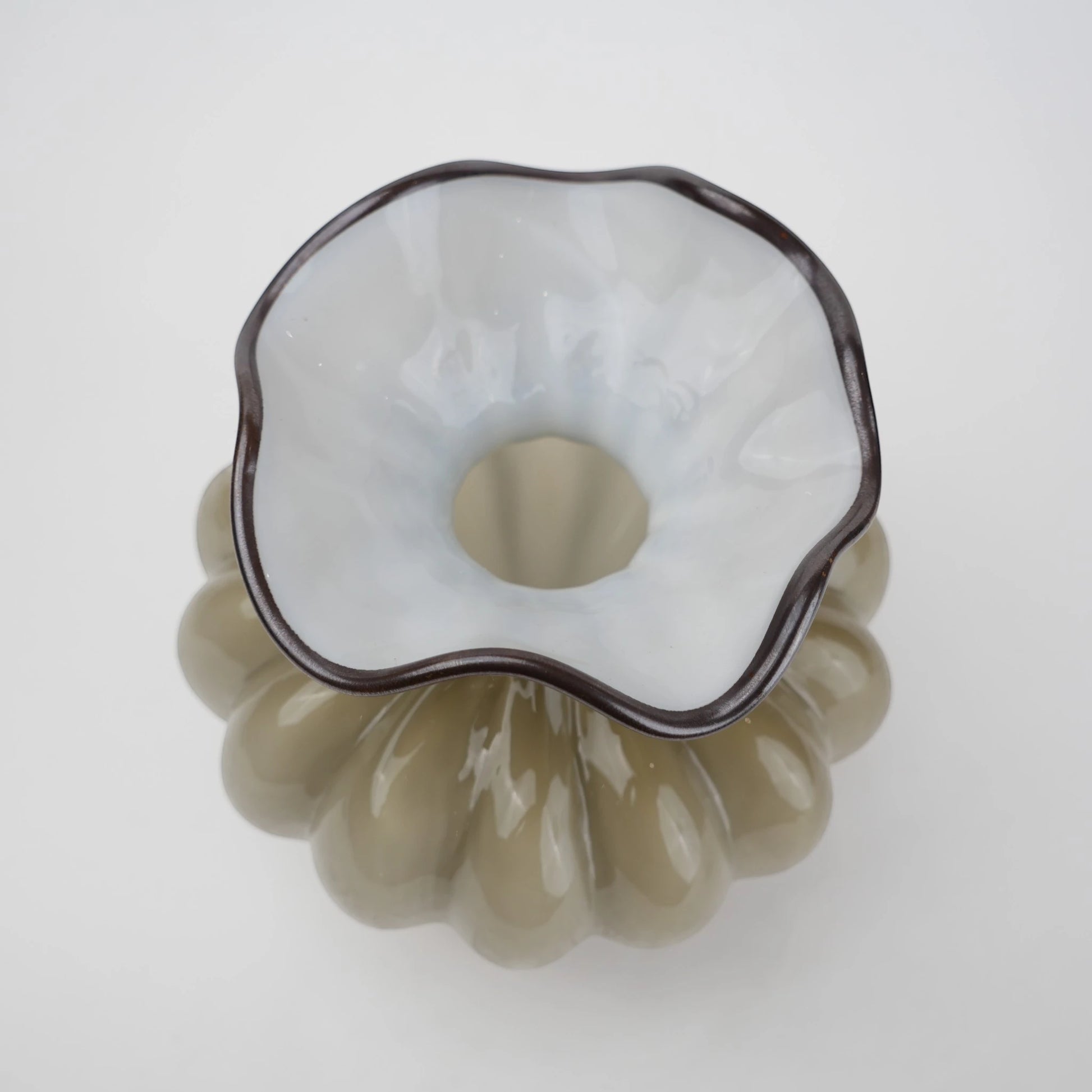 Ribbed glass vase with a smoky beige tint, featuring a rounded bulb shape and a wavy flared rim, designed as a modern decorative piece for home decor styling.