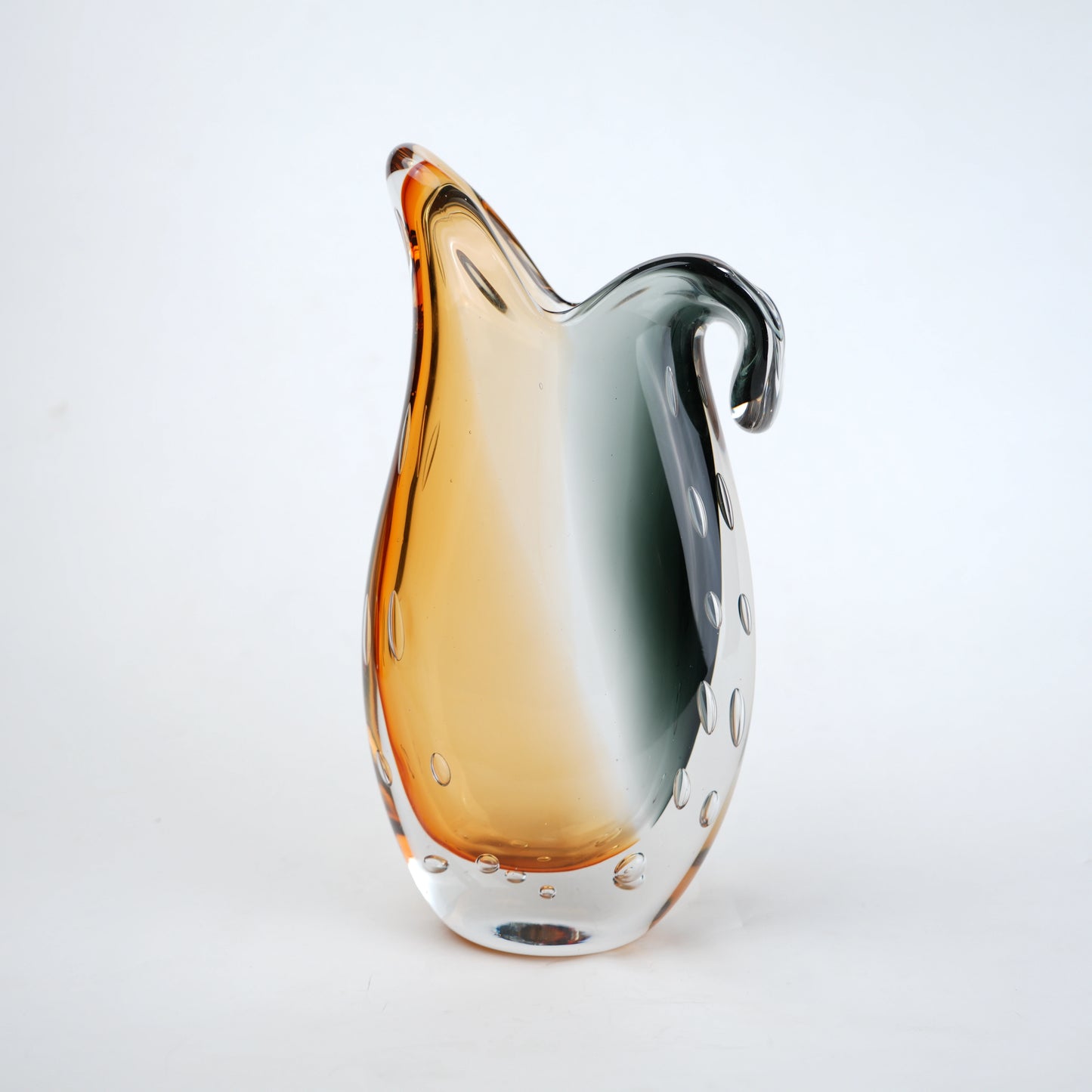 Glass pitcher with gradient color from orange to clear on a white background