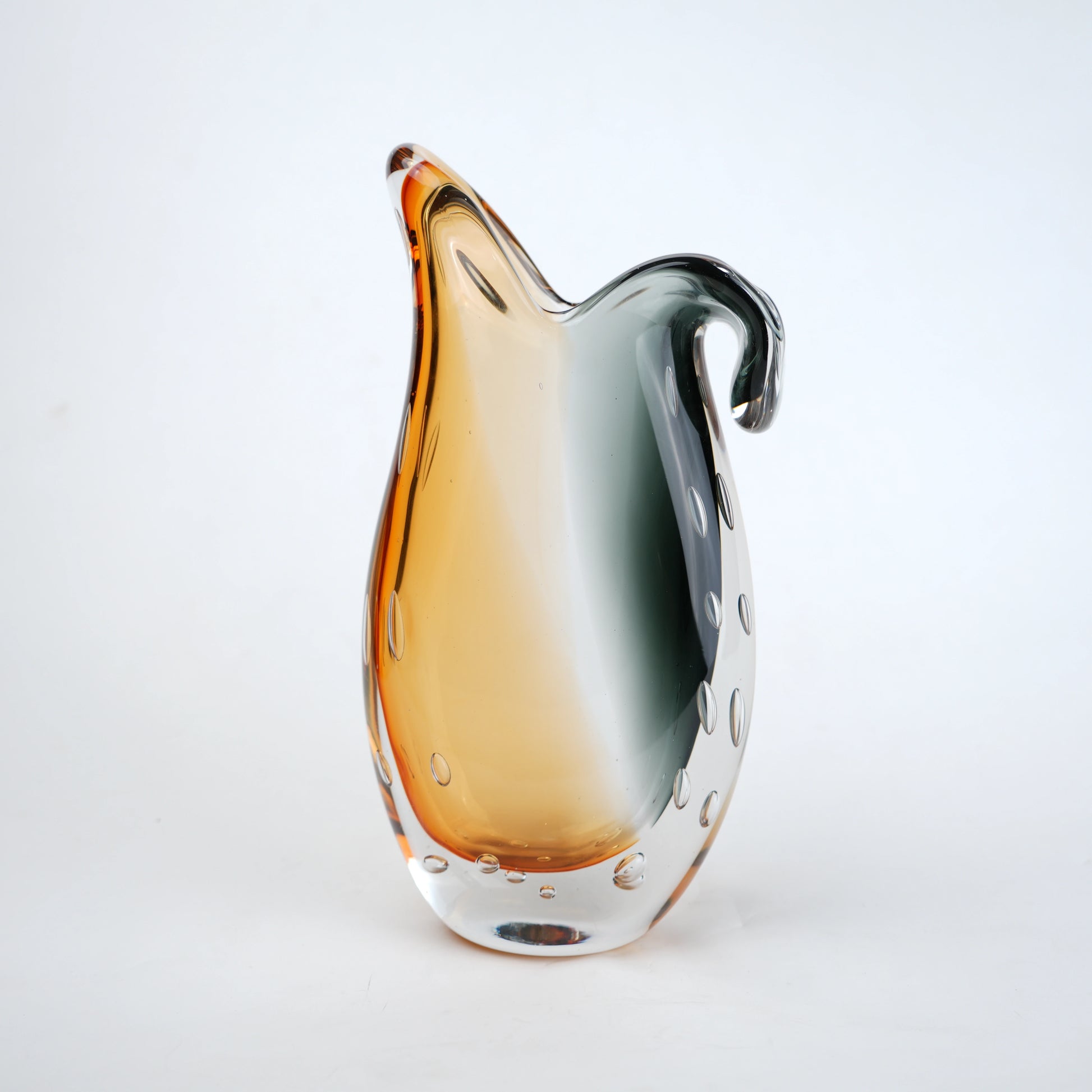 Glass pitcher with gradient color from orange to clear on a white background