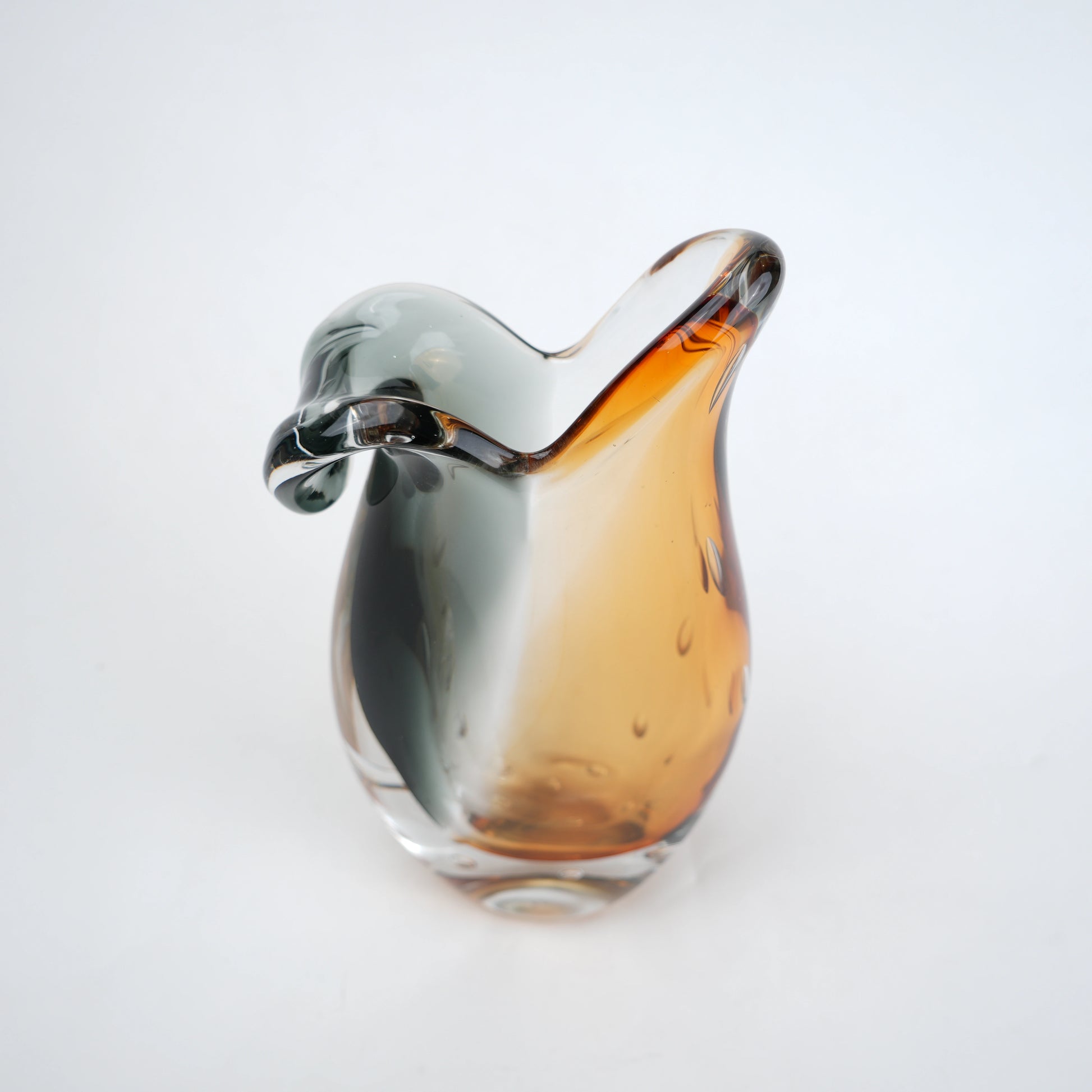 Glass object with gradient color from silver to amber on a white background