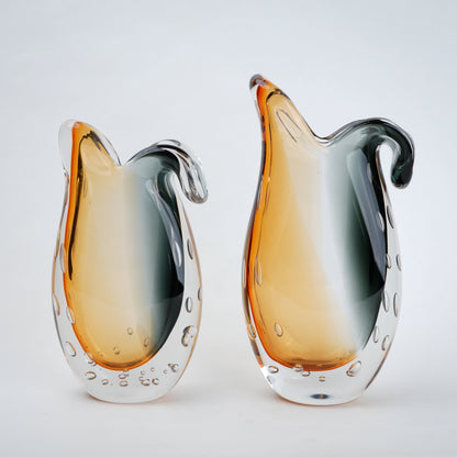 Two glass vases with orange and gray design on a white background