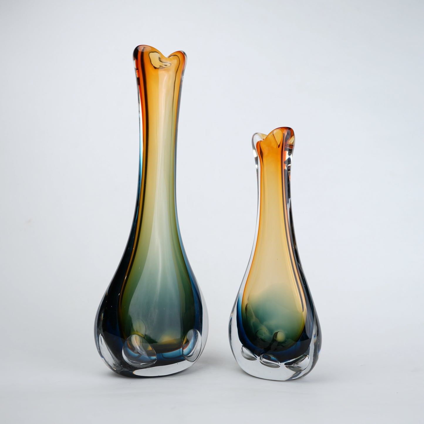 Two glass vases with gradient colors on a white background