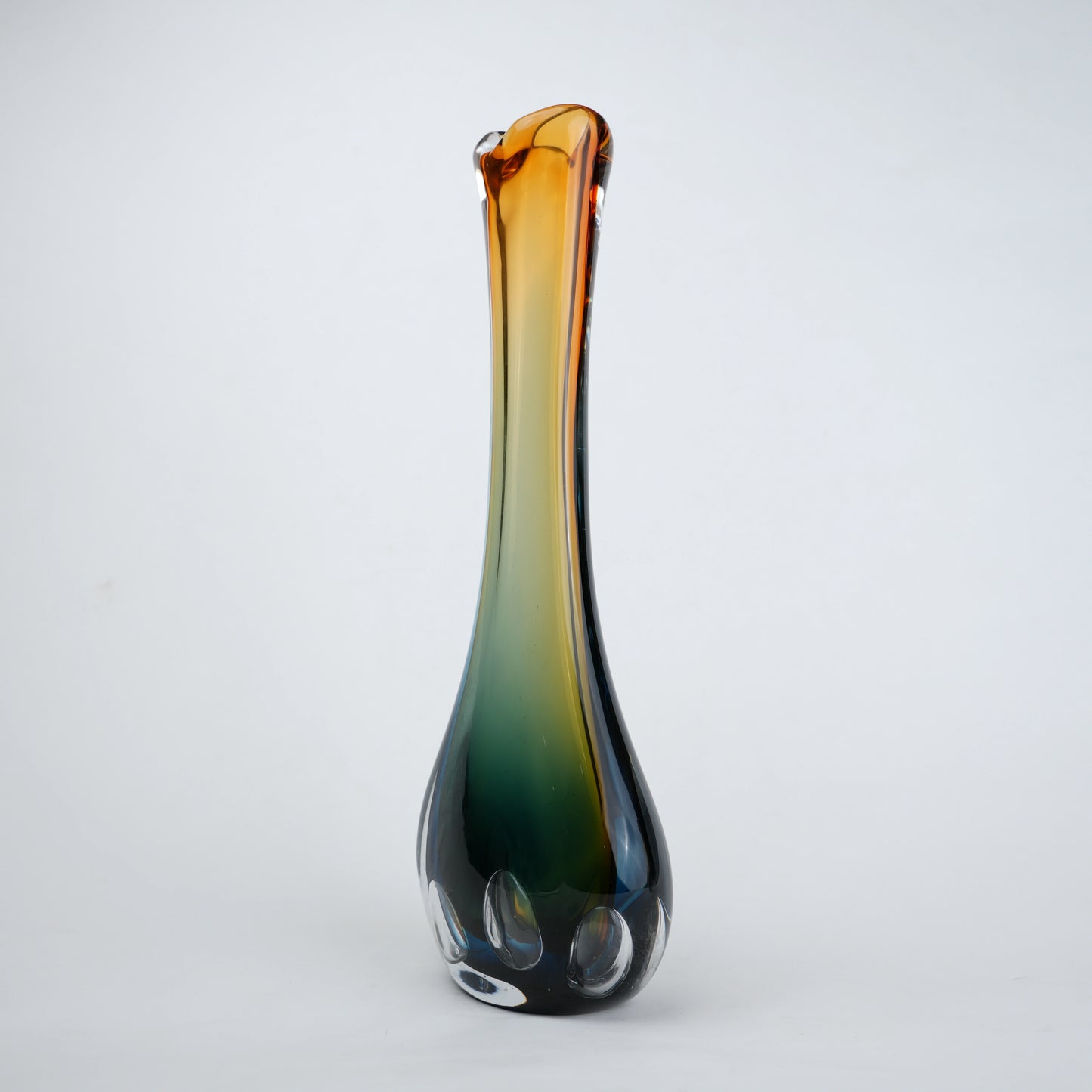 Glass vase with gradient color from brown to green on a white background