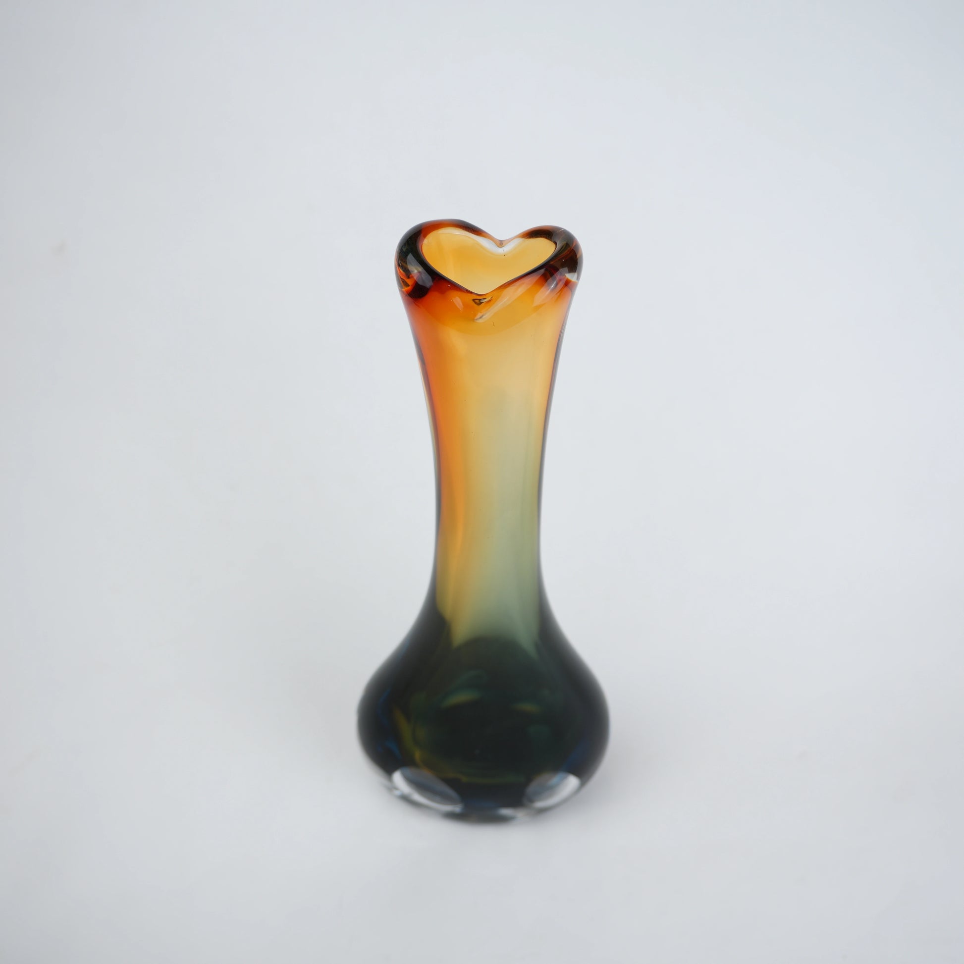 Glass vase with a heart-shaped opening on a white background