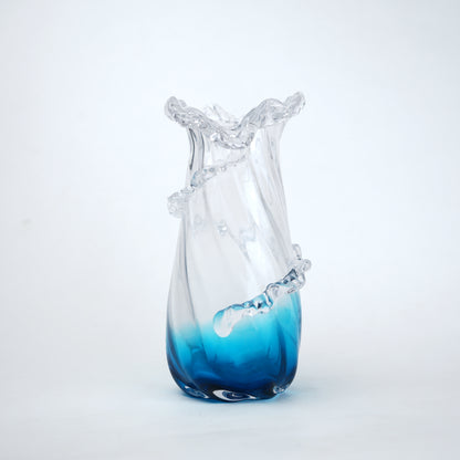 Glass vase with blue gradient at the base on a white background