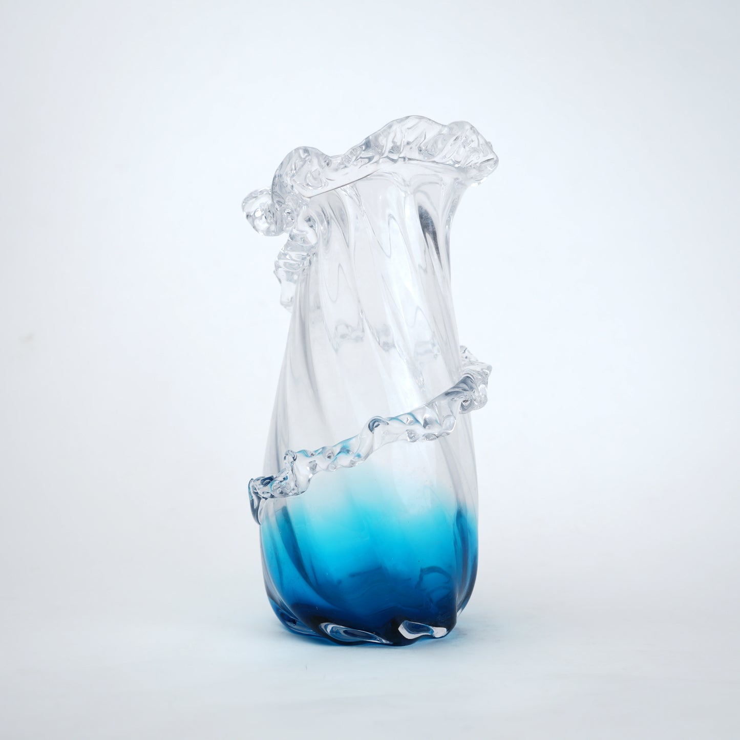 Glass vase with blue gradient at the base on a white background