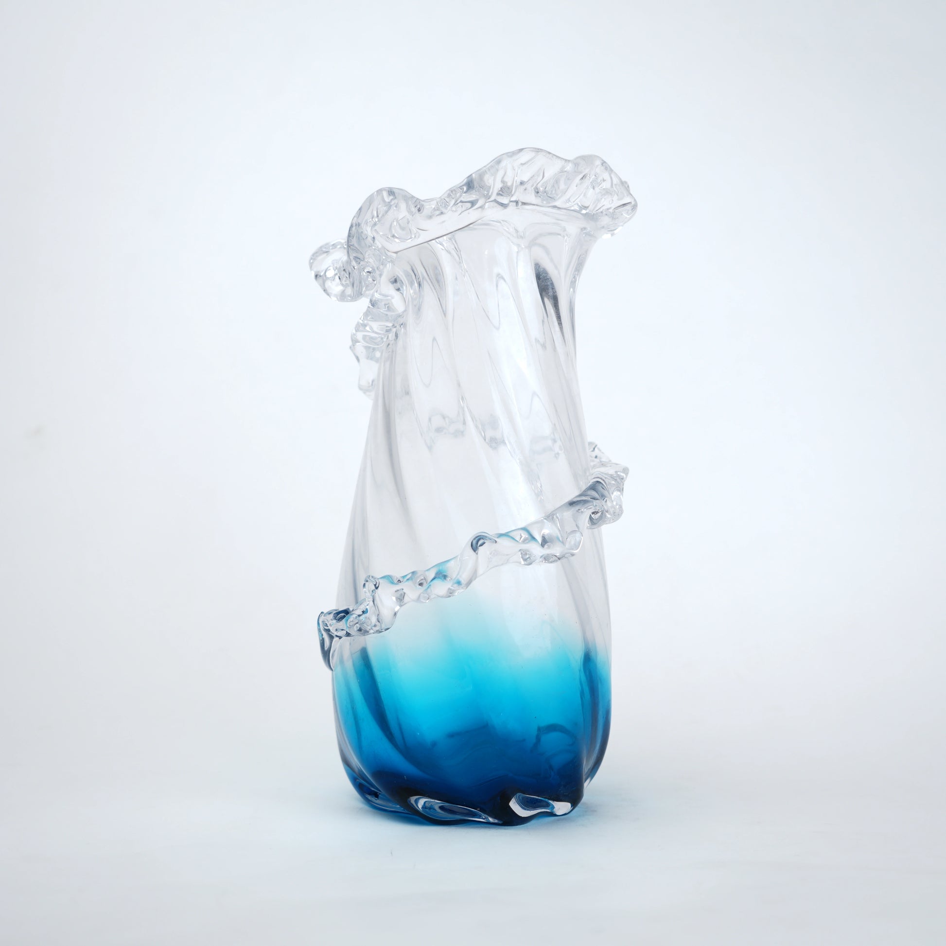 Glass vase with blue gradient at the base on a white background