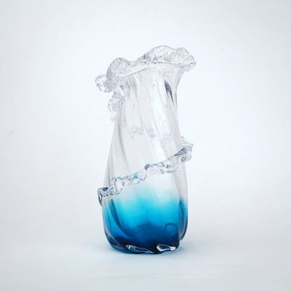 Glass vase with blue gradient at the base on a white background