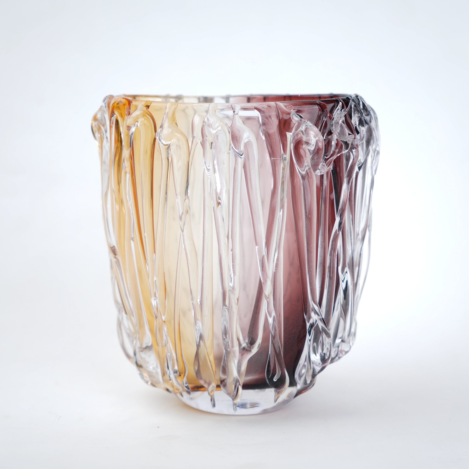 Multicolored glass vase with wavy design on a white background