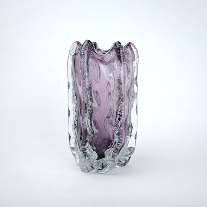 Purple glass vase with textured surface on a white background