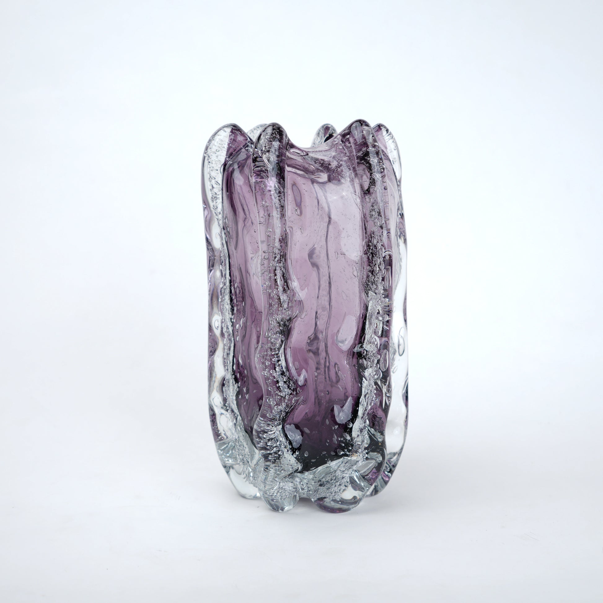 Purple glass vase with textured surface on a white background