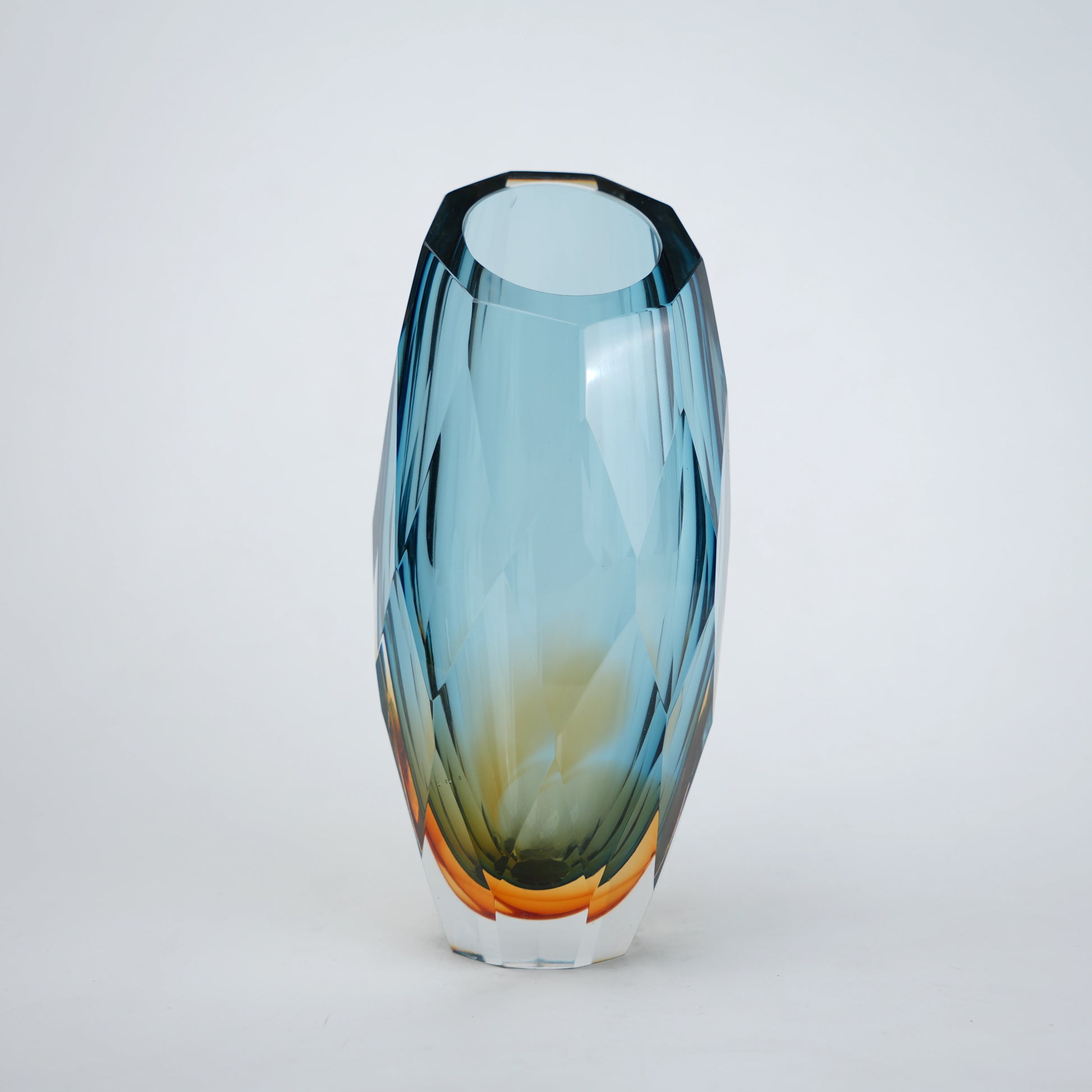 Decorative gradient glass vase with angular facets in blue and amber tones