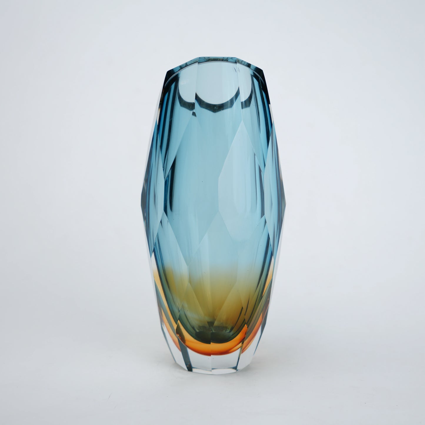 Decorative gradient glass vase with angular facets in blue and amber tones