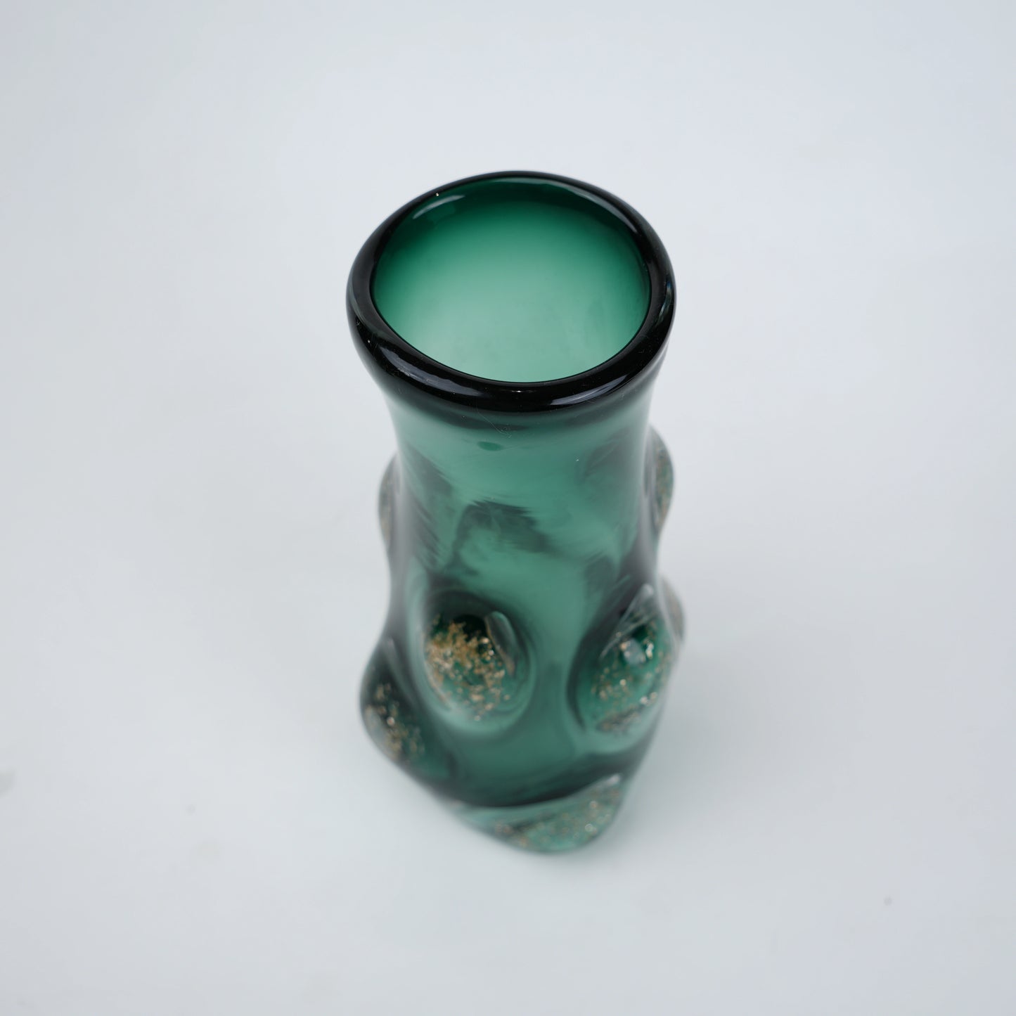Decorative green glass vase with flared neck and dimensional textured surface featuring subtle shimmer accents in premium finish