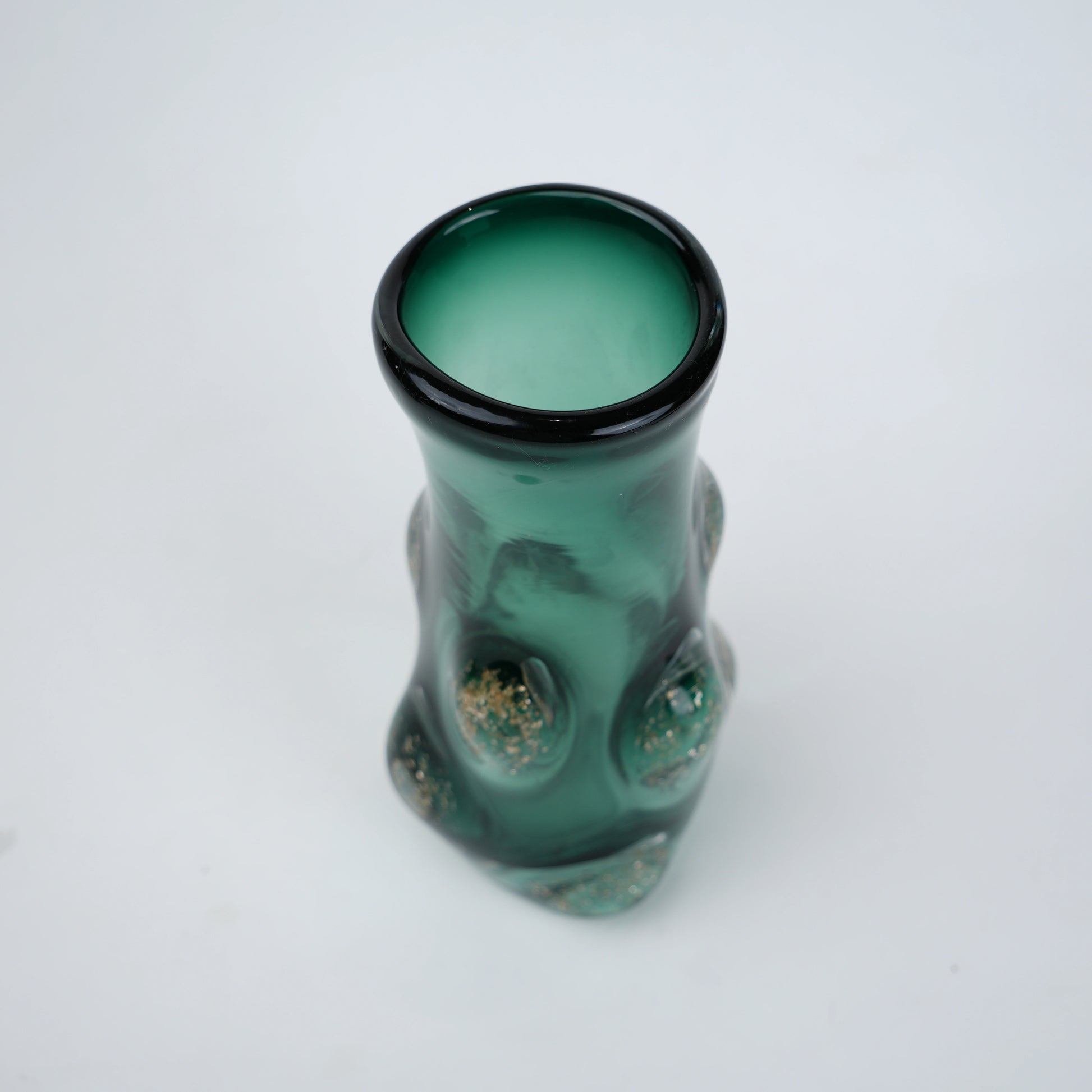 Decorative green glass vase with flared neck and dimensional textured surface featuring subtle shimmer accents in premium finish