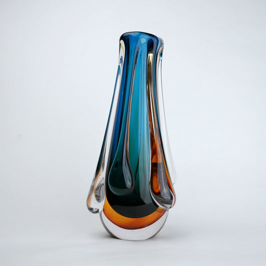 Aqua teal glass vase with amber base and flowing drip design in clear glass