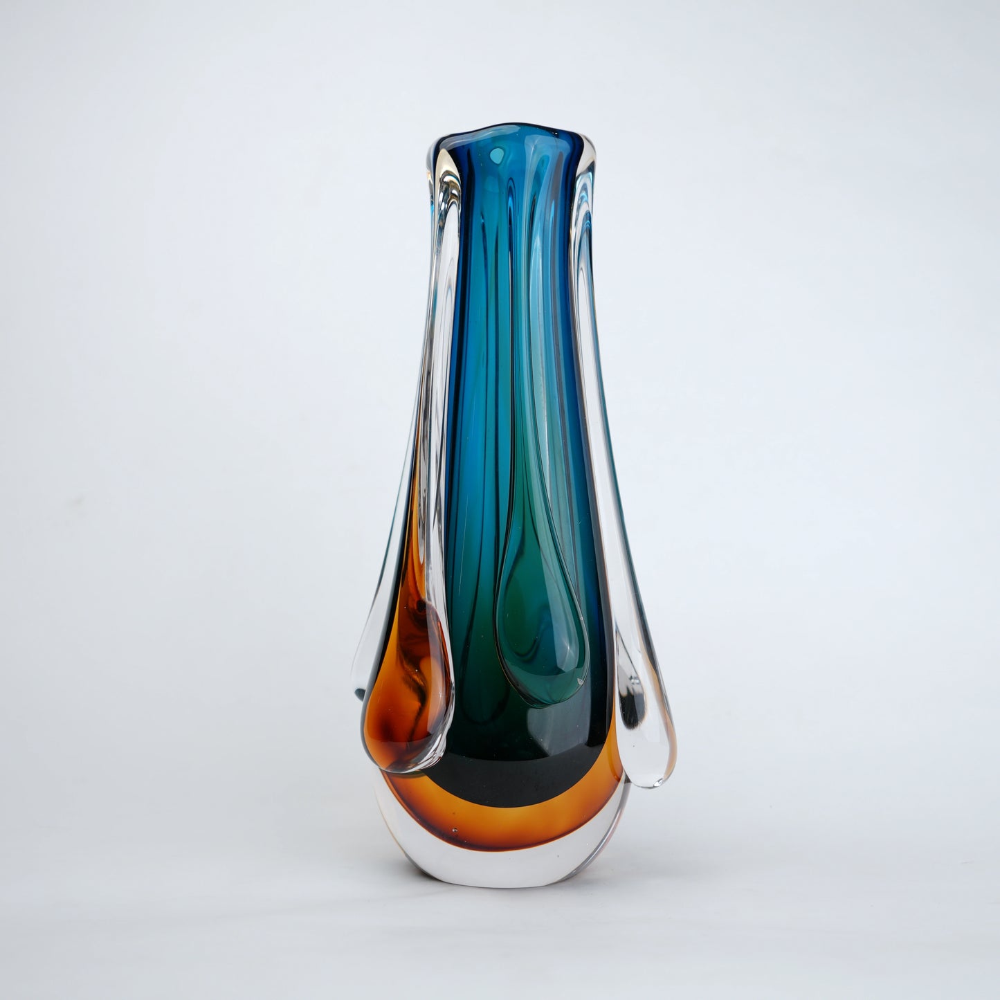 Aqua teal glass vase with amber base and flowing drip design in clear glass